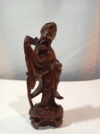 Antiga escultura em madeira representando figura oriental medindo 17cm de altura, possui pequenos bicados e pequena trinca em sua base.