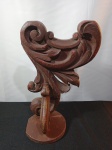 Peanha em madeira entalhada por motivos florais com patina, medindo: 38cm de altura, 24cm de largura e sua base 15cm de diametro.