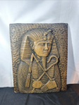 Diferente e antiga arte representando figura egípcia em alto relevo ricamente trabalhado em material não identificado, aparente algum minério ou derivado, medindo: 44cm de altura e 35,4cm de largura.