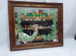 Espelho retangular de parede com moldura em madeira e decoração da cerveja Amstel. Medindo 51,5cm x 45cm.