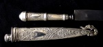 Faca gaucha de metal prateado espessado a prata decorada com motivos florais, lâmina de Inox Corneta. 18,5 cm de comprimento. Brasil, meados do século XX.