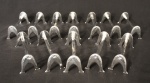 Jogo de doze descansos para talher em metal prateado, moldados no formato ferradura e ornados com laçarotes. Peças de meados do século XX.
