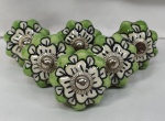 Meia dúzia de puxadores em porcelana no formato de flor pintados à mão com miolo prateado, medindo 3,5cm de diâmetro.