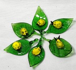 Miniatura,- Meia dúzia de enfeites no formato de pingente como folhas verdes com um pequeno inseto amarelo em vidro de murano, artesanal, medindo de 5cm a 5,5cm.