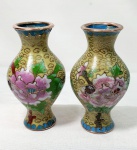 Cloisonné-  Par de pequenino vaso em cloisonné fundo  esverdeado, imagens florais com detalhes em bronze, apresenta pequeno defeito, vendido no estado, medindo 8cm de altura cada.