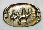 Pequeno cinzeiro em bronze polido com imagem em alto relevo de Maria e José no deserto, medindo 8cmX12cm.