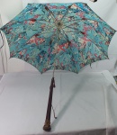 Antiguidade - Antigo guarda chuva na cor azul com cabo em madeira com pegador trabalhado com Deuses Gregos entre Anjos, amarelo pelo tempo e um pequeno quebrado no cabo, vendido no estado, medindo 83cm.