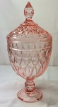 Cristal - Compoteira em grosso cristal na cor rose, com pé e tampa, medindo 31,5cm de altura por 15cm de diâmetro.