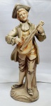 Antiga estatueta em resina italiana representando um violeiro, apresenta rachadura no braço e dedo, medindo 19cm de altura.
