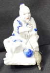 Porcelana-Estatueta  representando um velho pescador oriental em porcelana branca com detalhes em azul e dourado, medindo 11,5cm de altura.