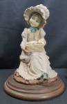 Estatueta Resina Italiana- Antiga estatueta em resina italiana representando uma menina pescadora com cesto sentada em um tronco com um cesto contendo pontinhos, base circular em madeira, ricamente detalhada medindo 24cm de altura.