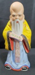 Bela estatueta em porcelana ricamente detalhada de Fukurokuju (Deus da felicidade, sabedoria, longevidade e fertilidade):De origem chinesa, seu nome se traduz literalmente como: Fuku ( Felicidade), Roku (Riqueza) e Ju (Longevidade). De testa longa - simbolo de sua sabedoria - Fukurokuju possui barba branca e comprida, é careca e se veste assim como os velhos sábios chineses. Traz consigo um pergaminho, medindo 22cm de altura.