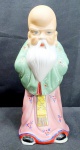 Bela estatueta em porcelana ricamente detalhada de Fukurokuju (Deus da felicidade, sabedoria, longevidade e fertilidade):De origem chinesa, seu nome se traduz literalmente como: Fuku ( Felicidade), Roku (Riqueza) e Ju (Longevidade). De testa longa - simbolo de sua sabedoria - Fukurokuju possui barba branca e comprida, é careca e se veste assim como os velhos sábios chineses. Traz consigo um pergaminho, medindo 22cm de altura.