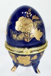 Belíssimo porta joias em porcelana no formato do ovo de  Fabergé  na cor azul cobalto com imagens florais dourada, 10cm de altura.
