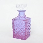 Garrafa para whisky  em cristal década de 1950 com pequeno bicado na borda na cor lilás. Medida: 23cm de altura x 9,5cm x 9,5cm.