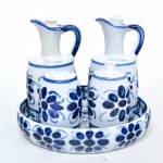 MONTE SIÃO - Galheteiro em porcelana nas cores azul e branco decorado por motivo floral composto de : Bandeja(3cm x 17cm de diâmetro). 1 saleiro(8cm x 5cm). Paliteiro(9cm x 6cm). Azeiteiro (14cm x 6cm x 7cm). Jarra para vinagre(14cm x 6cm x 7cm).