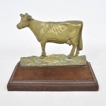 Belíssima escultura em bronze dourado representando figura de vaca feita à mão com base em madeira entalhada. Base: 22 cm x 13 cm. escultura: 19 cm x 15 cm