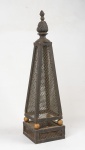Possivelmente antiga lanterna em ferro e metal entrelaçado, apoiado sobre quatro bolas pintadas de dourado, encimada por pinha . Medida: 59 cm x 16 cm