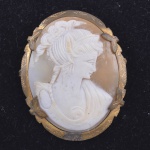 Broche camafeu, art-noveau representando busto feminino, fundo em alabastro. Medida: 4,5cm x 3,5cm. Peso bruto: 8,6g