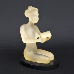 Escultura em acrílico representando figura feminina. Medida: 18 cm x 11 cm x 13 cm; Em perfeito estado.