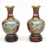 Par de Vasos cloisonne com motivo floral em marrom, policromia. Realces dourados. Bocal em  bronze, fundo em cerâmica. Acompanha peanhas. Medidas: vasos; 16cm alt. x 10cm diâmetro; peanhas 7cm alt. x 3cm diâmetro.