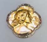 Broche em ouro amarelo e platina com incrustação de rubilitas e brilhantes  com figura representando dama em relevo adornada por três estrelas. Peso: 10 gramas. Medida: 3,3 gramas.