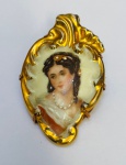 LIMOGES - Broche em porcelana francesa com pintura feita à mão representando dama com base possivelmente em ouro baixo. Medida: 6 cm x 4 cm