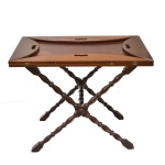 Mesa dobrável em madeira nobre, ricamente entalhada, possui 4 pés e tampo reversível para formato oval, um pé necessita pequeno conserto. Medida: 68cm x 120cm x 78 cm