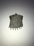 Pequena bolsinha em prata 800. Medida: 9cm x 7cm. Peso bruto: 24,3g.  Possui pequeno defeito.
