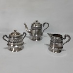 TEIXEIRA - Antigo conjunto para chá e café em metal cinzelado, expessurado à prata. Belos detalhes. Sinais de desgaste. Dimensôes: maior peça 17 cm x 2 cm / menor peça 12 cm x 14 cm .