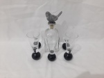 Pequena licoreira em vidro com tampa na forma de ave em metal com 5 copos de aperitivo em vidro com base pesada. Medindo a licoreira 17,5cm de altura.