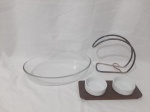 Lote composto de travessa oval em vidro temperado, suporte de garrafa e suporte em madeira com 2 bowls para pasta. Medindo a travessa 35cm x 24,5cm x 6,5cm de altura.