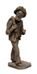 Zé do Carmo (Goiana/PE, 1933-2019). HOMEM DE CHAPÉU CARREGANDO TROUXA. Escultura em barro cozido. Altura = 38 cm. Falta parte da mão.