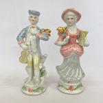 Par de estatuetas em porcelana na cor branca com policromia e dourado representando casal de musicos com pássaro, med. 24cm de altura