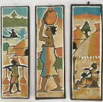 Lote com três quadros decorativos com desenhos em areia sobre madeiras de origem africana. Med.: 29x9cm