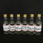 Lote com 6 garrafas pequenas de vidro com pedra na tampa com frases de poção do amor em latim. Med.: 11cm de altura.