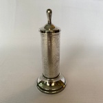 WOLFF - Paliteiro em metal espessurado a prata com pegador pontudo e corpo com detalhes de flores e arabescos. Med.: 15cm de altura.