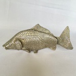 Porta guardanapo em metal espessurado a prata em formato de peixe. Med.: 23cm de largura e 10cm de altura.