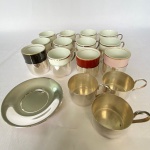 Lote com diversas peças sendo doze xícaras de porcelana Mauá com suporte em metal espessurado a prata, quatro suportes para xícaras e dois pires. Med.: 5cm de altura. Um xícara com bicado e uma com rachadura