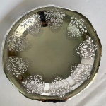 WOLFF - Fruteira em metal prateado decorado com flores, bordas vazadas e três pés em volutas. Med.: 30cm de diâmetro e 5cm de altura.Apresenta riscados