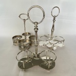 Lote com 3 (três) suportes para galheteiros em metal espessurado a prata, sendo: Dois WOLFF. Maior medindo: 21cm de altura e 15cm de largura.