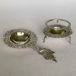 PRATA 800 - Antigo coador de chá com suporte em prata contrastada. Decorada com barco no pegador, volutas e arabescos. Med.: 15cm de largura e 4,5cm de altura e pesando 127g