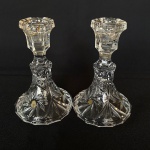 Par de castiçais para vela de cristal europeu translúcido lapidado com flores. Med.: 13cm de altura e 8cm de diâmetro. Possui restauros no bocal.