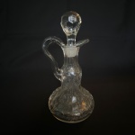 Galheteiro de vidro com detalhes em volutas e flores. Med.: 18cm de altura e 9cm de diâmetro.