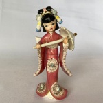 C L & M - Lipper & Mann Creations - Antiga escultura em porcelana japonesa de gueixa com guarda-chuva, com policromia e decorações em alto relevo, med. 18cm de altura