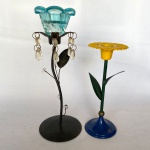 Dois suporte para vela em metal, sendo um em formato de flor med. 18cm, e um em suporte em vidro na cor azul, med. 24cm - Apresenta desgastes