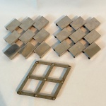 Lote com 3 (três) descansos para panela, sendo: Dois Meridional no padrão xadrez em inox 19X17cm e um Articulado em metal med. 12X12cm
