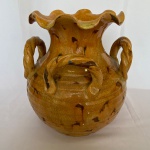 Vaso em cerâmica com bordas onduladas e 4 alças retorcidas, possui poucos bicados na base. Med.: 30 cm alt