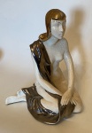 Escultura de porcelana representando mulher. 20 x 22,5 x 27 cm de altura