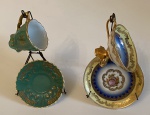 2 xicaras com seus pires de porcelana, sendo 1 Schmidt e a outra TD. Maior: 9 cm de laça a borda x 5 cm de altura. Pires: 10,5 cm de diâmetro. Acompanham suportes